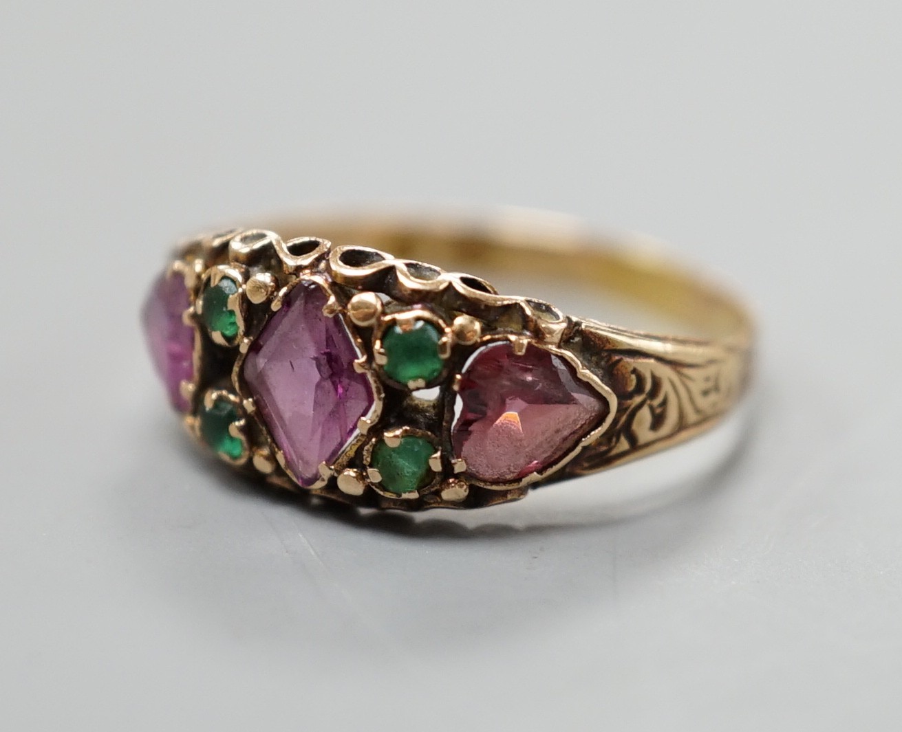 A Victorian gold, garnet? and emerald set half hoop ring, size N, gross weight 1.8 grams.